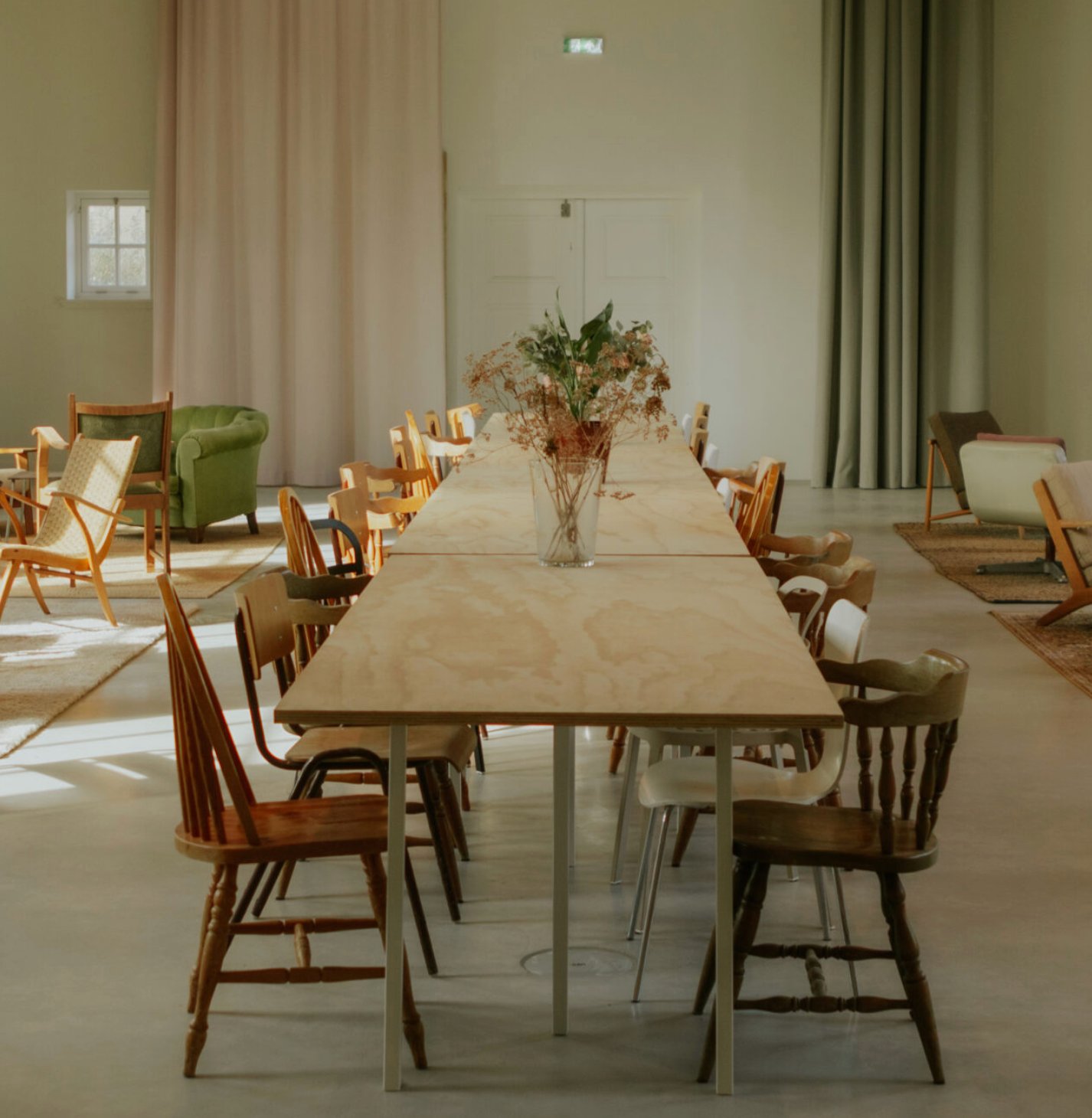 Helium House on Texel: a long wooden table with chairs in soft daylight